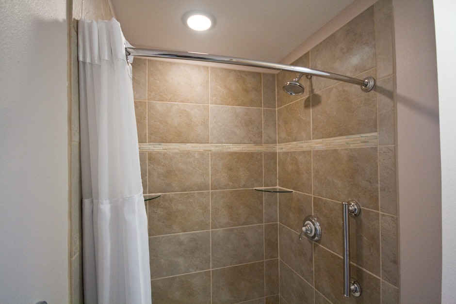 beige sandstone look shower wall tile with ceramic linear accent band custom bathroom remodel