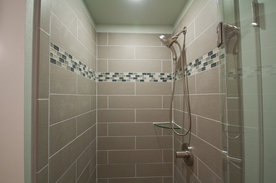 Bismarck ND area bathroom remodeler: Porcelain tile shower with glass tile accent band.
