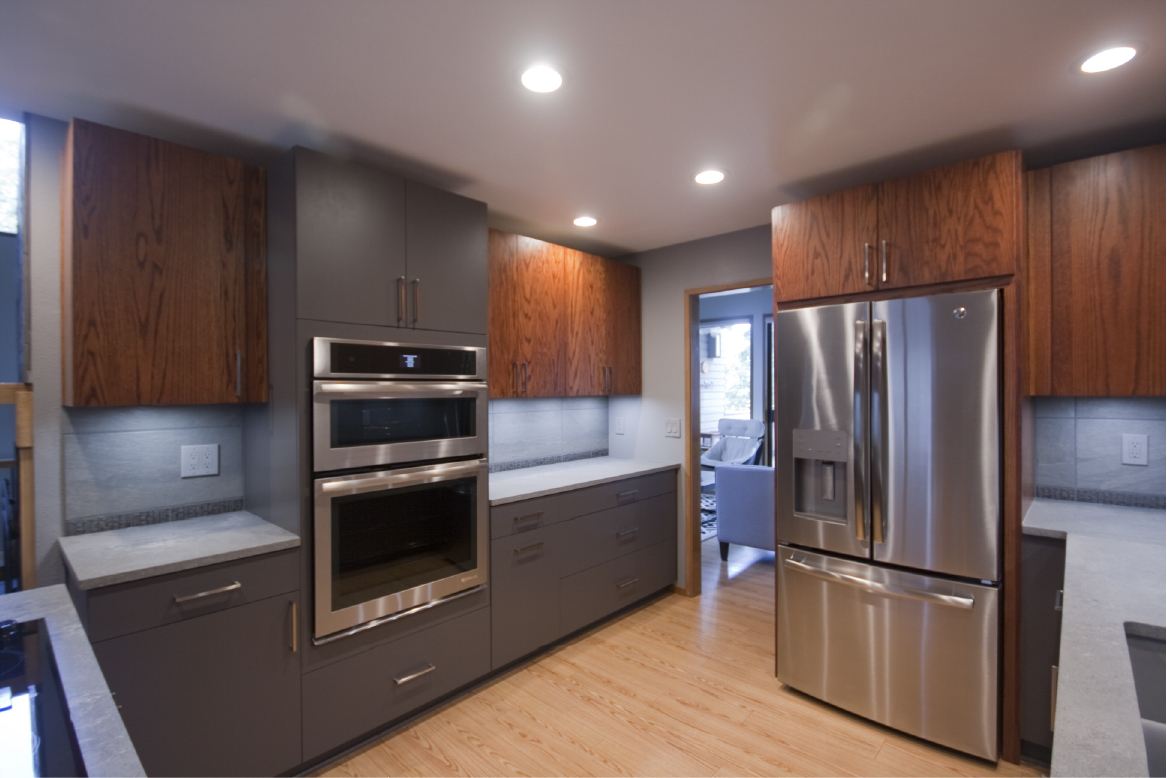 Oak and blue slab front kitchen cabinets with double oven