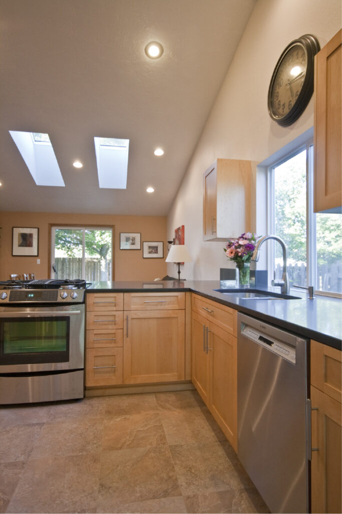 Kitchen opens to living & dining area with new skylights.