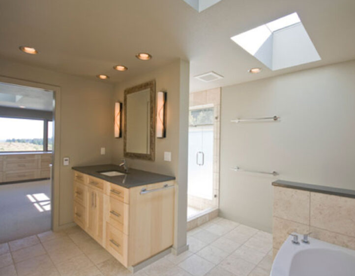 Bismarck ND bathroom remodeler: Master bedroom and bathroom with travertine tile and maple vanity cabinets.