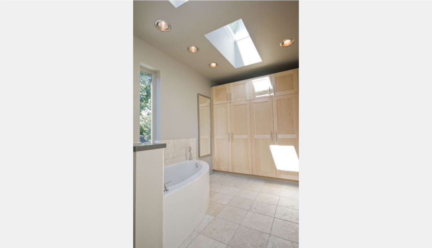 curved bathtub and cabinetry as closet