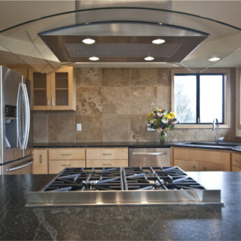 Soapstone kitchen counter with curved glass range hood