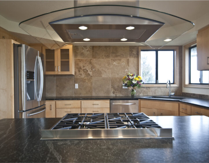 Soapstone kitchen counter with curved glass range hood