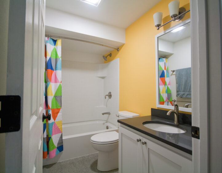 Bright geometric curtain, yellow accent wall bathroom remodel