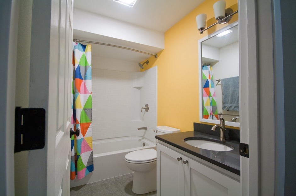 Bright geometric curtain, yellow accent wall bathroom remodel