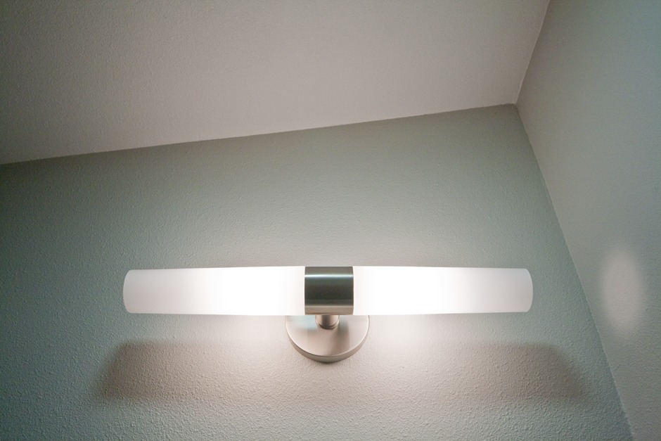 mid-century style light sconce in bathroom