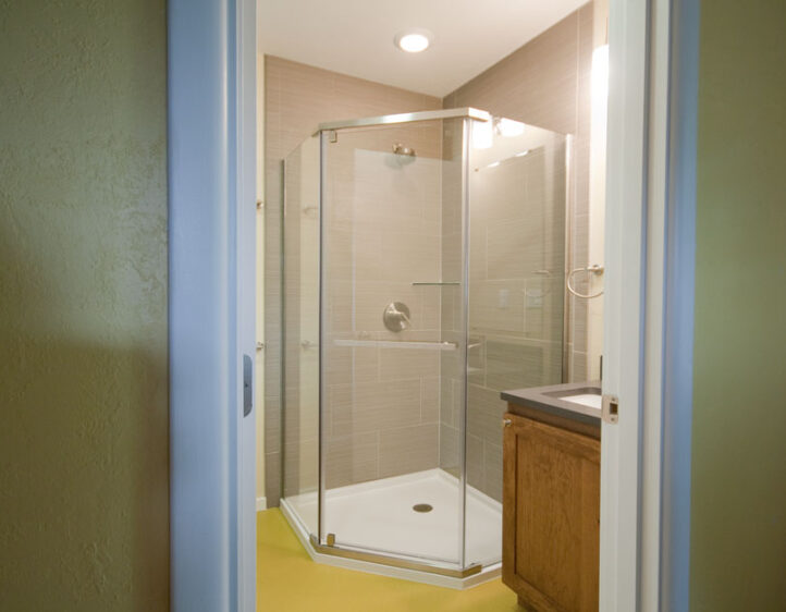 Luxury neo-angle shower with chartreuse sheet flooring.