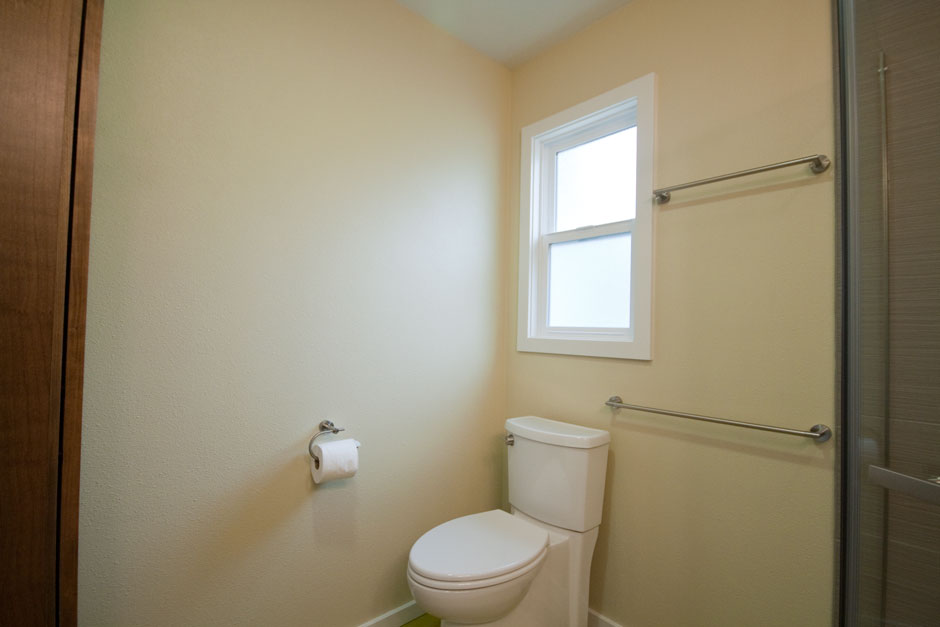 Remodel showing low-flow toilet in front of single-hung window.