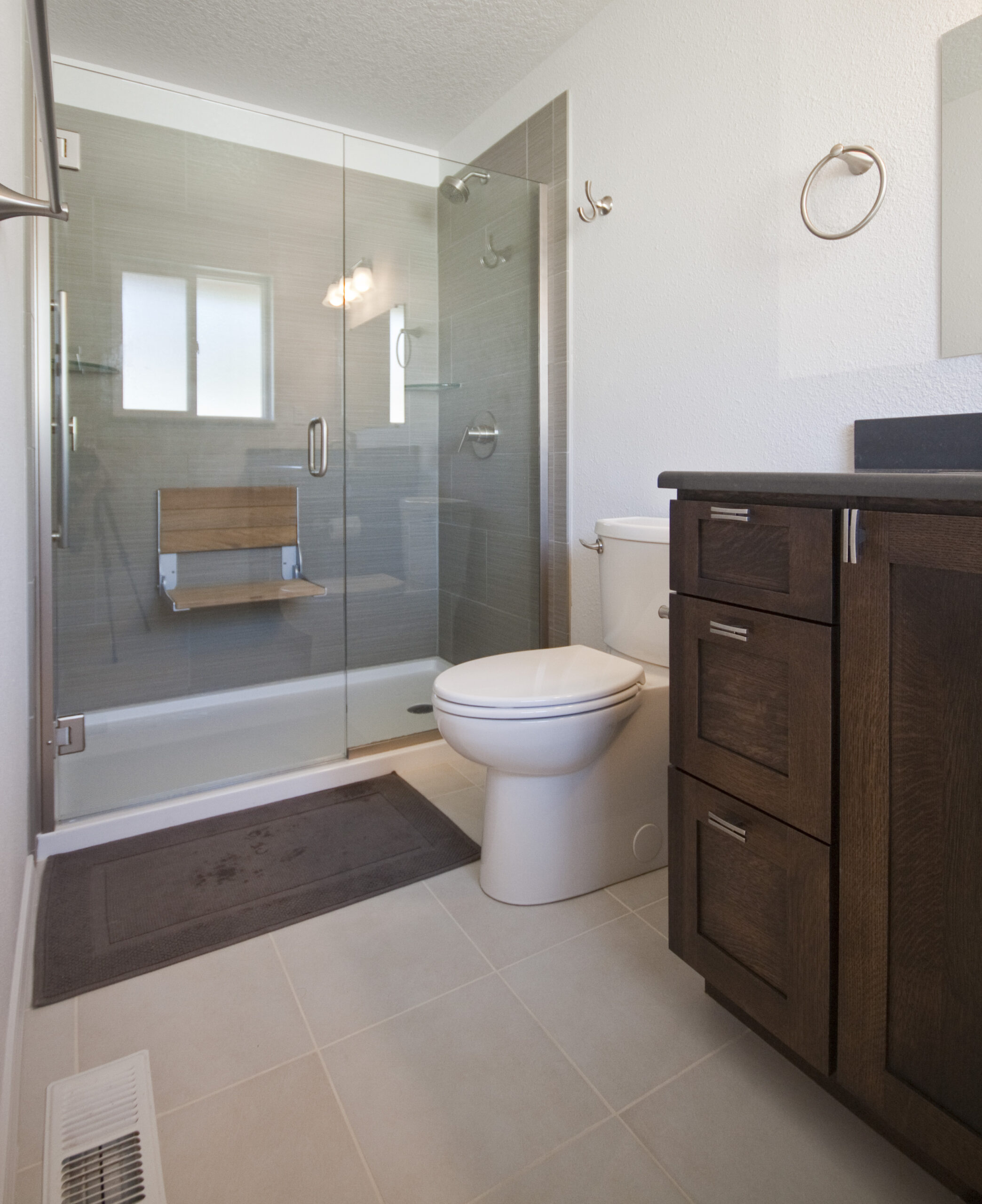 Tiled bathroom remodel with dark brown oak cabinets