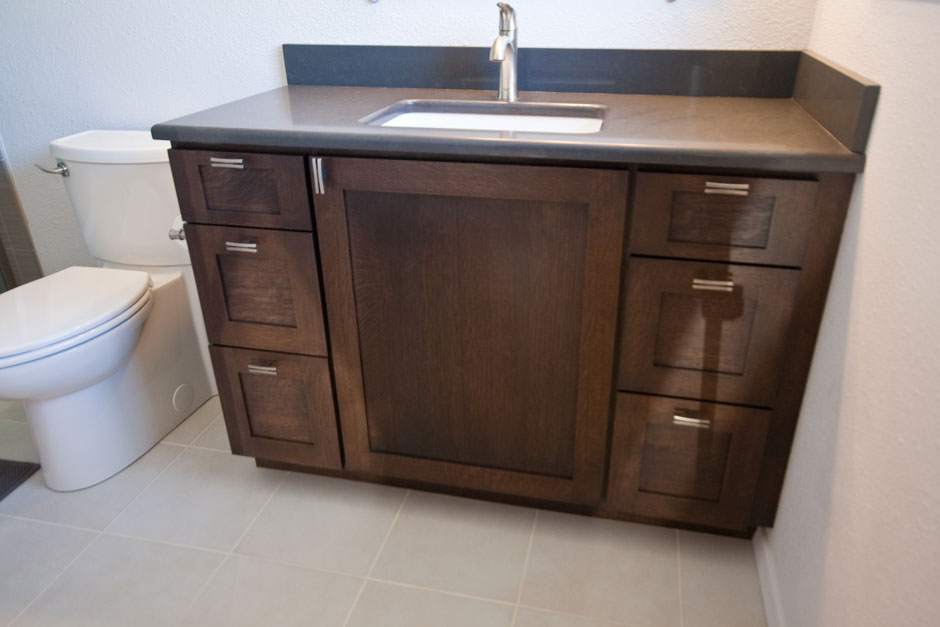 dark brown stained white oak vanity cabinets with dark gray quartz counter
