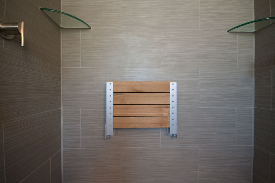 folding teak shower seat in the up position
