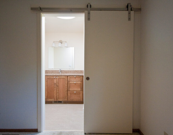Sliding master bathroom barn door leading to newly remodeled bathroom.