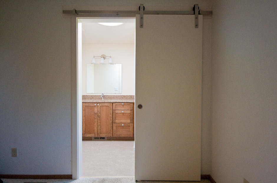 Sliding master bathroom barn door leading to newly remodeled bathroom.