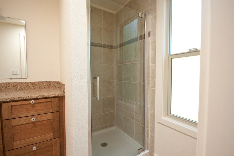 Design and construction of a tile shower with acrylic pan and heavy glass shower door.