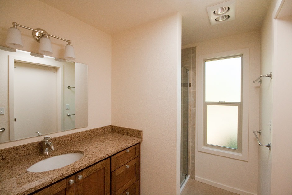 Bathroom remodel with granite-look quartz counter and traditional style.