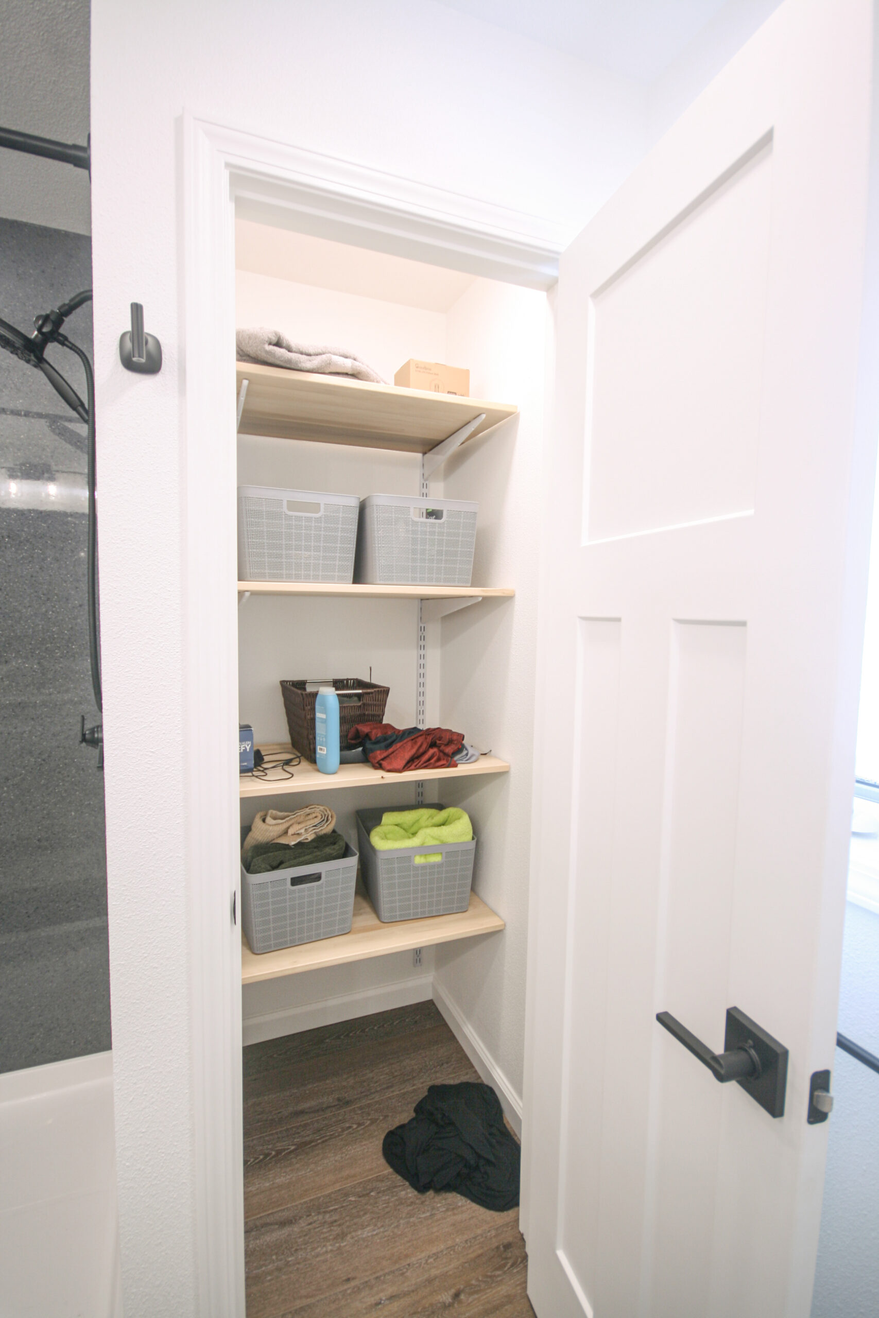 This bathroom remodel includes a well-lit closet with solid wood adjustable shelves.